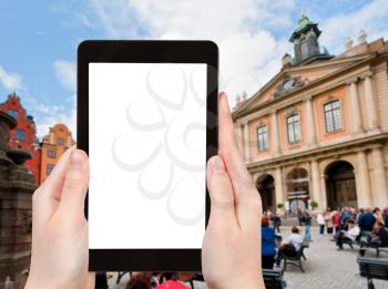 travel concept - tourist photographs Swedish Academy on Stortorget square in Stockholm, Sweden on tablet pc with cut out screen with blank place for advertising