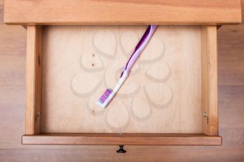 top view of toothbrush in open drawer of nightstand