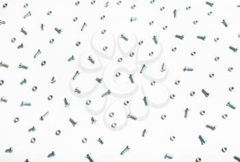 above view of many steel bolts and nuts on white background