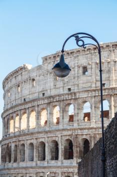 travel to Italy - urban lantern and Colosseum on background in Rome city