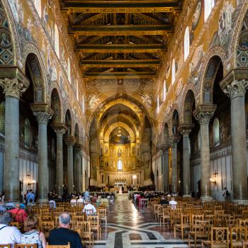 MONREALE, ITALY - JUNE 25, 2011: tourists in interior Duomo di Monreale in Sicily. The cathedral of Monreale is one of the greatest examples of Norman architecture, it was begun in 1174