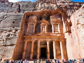 PETRA, JORDAN - FEBRUARY 21, 2012: view of al-Khazneh temple (The Treasury) and tourists in ancient Petra. Rock-cut town Petra was established about 312 BC as the capital city of the Arab Nabataean