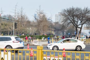 BEIJING, CHINA - MARCH 19, 2017: car and people at green boulevard on Guangxhang East Side Road in spring. This is area on south from Tiananmen Square near Beijing central street Qianmen
