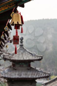 LUOYANG, CHINA - MARCH 20, 2017: bell and pagoda on East Hill of Chinese Buddhist monument Longmen Grottoes in spring. The complex was inscribed upon the UNESCO World Heritage List in 2000