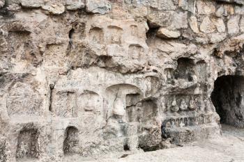 LUOYANG, CHINA - MARCH 20, 2017: carved walls and caves in West Hill of Chinese Buddhist monument Longmen Grottoes. The complex was inscribed upon the UNESCO World Heritage List in 2000