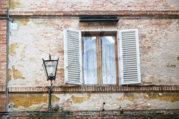 travel to Italy - lantern near window of medieval house in Siena city in winter