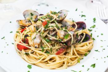 typical italian food - spaghetti alle vongole on plate in sicilian restaurant