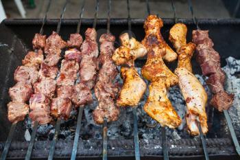 travel to Crimea - skewers with lamb pieces and chicken wings shish-kebab on grill in tatar outdoor cafe