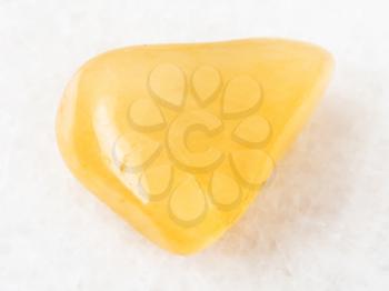 macro shooting of natural mineral rock specimen - polished yellow Aventurine gem stone on white marble background from India