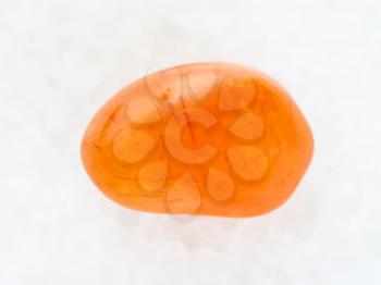 macro shooting of natural mineral rock specimen - polished Carnelian gemstone on white marble background