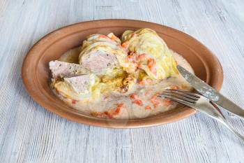 russian cuisine - cut cabbage rolls stuffed with minced meat with rice on ceramic plate on gray wooden board