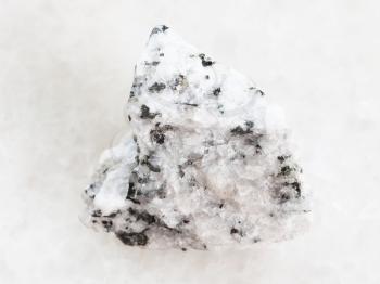 macro shooting of natural mineral rock specimen - rough Diorite stone on white marble background