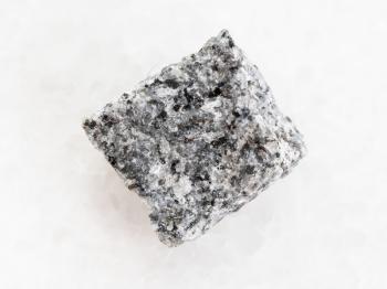 macro shooting of natural mineral rock specimen - raw Gabbro stone on white marble background