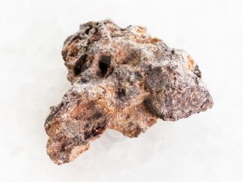 macro shooting of natural mineral rock specimen - raw Basalt stone on white marble background