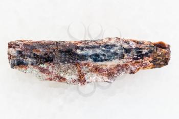 macro shooting of natural mineral rock specimen - rough Schist stone with Kyanite crystal on white marble background