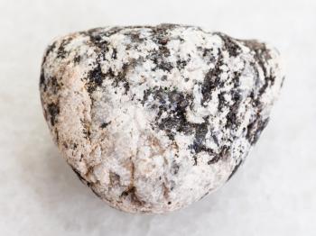macro shooting of natural mineral rock specimen - Diorite stone on white marble background
