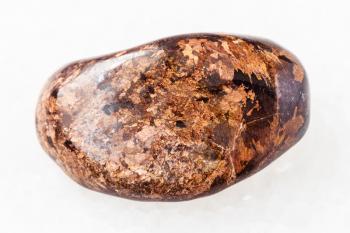 macro shooting of natural mineral rock specimen - polished Bronzite gemstone on white marble background from Peru