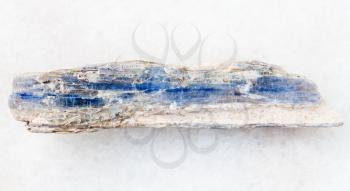 macro shooting of natural mineral rock specimen - raw blue kyanite stone on white marble background from Brazil