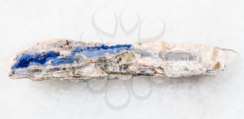 macro shooting of natural mineral rock specimen - rough blue kyanite stone on white marble background from Brazil