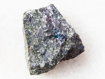 macro shooting of natural mineral rock specimen - raw bornite stone on white marble background from Azerbaijan