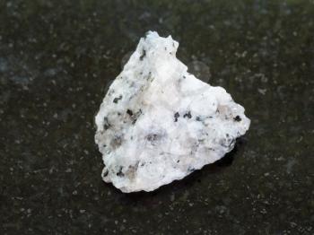 macro shooting of natural mineral rock specimen - raw Diorite stone on dark granite background