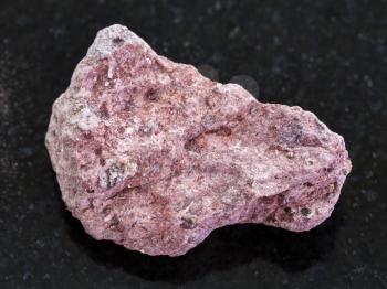 macro shooting of natural mineral rock specimen - Ash Tuff stone on dark granite background