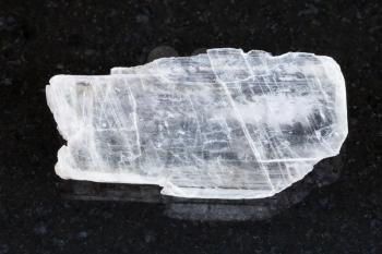 macro shooting of natural mineral rock specimen - rough crystal of Gypsum gemstone on dark granite background