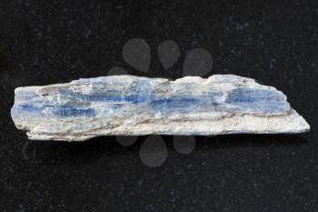 macro shooting of natural mineral rock specimen - rough blue kyanite stone on dark granite background from Brazil