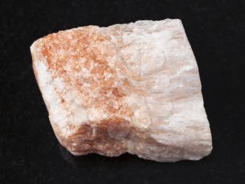 macro shooting of natural mineral rock specimen - raw Selenite stone on dark granite background from Vodinskoye mine in Samara Region of Russia