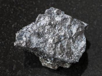 macro shooting of natural mineral rock specimen - rough Magnetite ore on dark granite background from Kovdor, Karelia, Russia