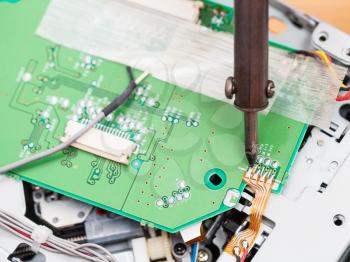 electric circuit board repair with soldering iron close up