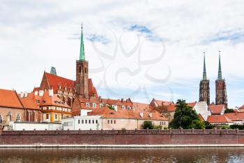 travel to Poland - towers of Collegiate Church of the Holy Cross and St Bartholomew and Cathedral of St John the Baptist in Ostrow Tumski district in Wroclaw city from Oder River