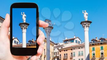 travel concept - tourist photographs column on Piazza dei Signori in Vicenza city in Italy on smartphone