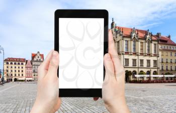 travel concept - tourist photographs main Market Square (Rynek) in Wroclaw city in Poland in autumn morning on tablet with cut out screen for advertising logo