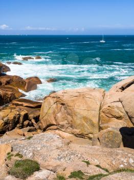 travel to France - stone beach of English Channel in Ploumanac'h site of Perros-Guirec commune on Pink Granite Coast of Cotes-d'Armor department in the north of Brittany in sunny summer day