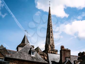 travel to France - blue sky with white clouds over roof of urban houses and tower of cathedral in Treguier city in summer in Brittany
