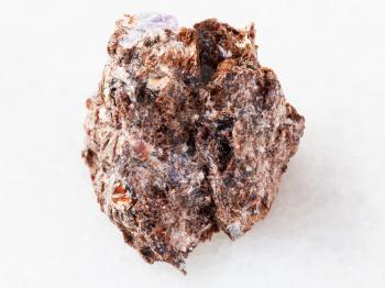 macro shooting of natural mineral rock specimen - rough Phlogopite stone on white marble background from Tajikistan