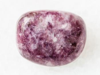 macro shooting of natural mineral rock specimen - polished Lepidolite gemstone on white marble background from Brazil