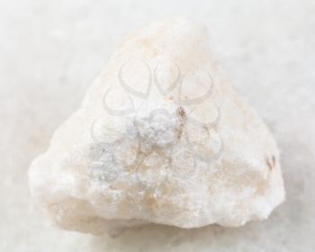 macro shooting of natural mineral rock specimen - raw anhydrite stone on white marble background from Adygea, Russia