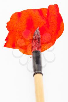 red colored round goat hair tip of paintbrush for sumi-e ( suibokuga) painting in red blot on white paper close up