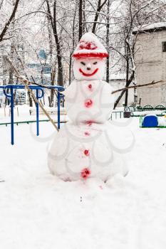 snowman at public urban yard in residential district of Moscow city in overcast winter day