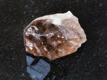 macro shooting of natural mineral - smoky quartz crystal on black granite from Ural Mountains