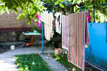 linen dries on ropes at backyard of country house in sunny summer day in Kuban region of Russia