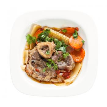 top view of italian dish Ossobuco in white plate isolated on white background