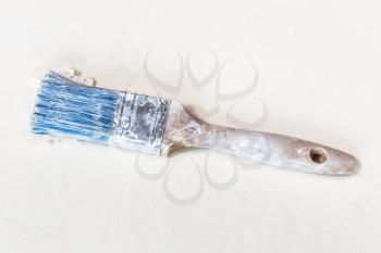 top view of used dried paint brush on white plastered surface