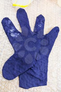 workshop of hand making a fleece gloves from blue Merino sheep wool using wet felting process - wet felted glove before matting