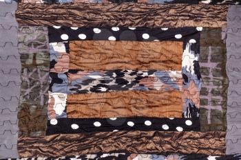 detail of handmade brown patchwork scarf from various stitched silk pieces