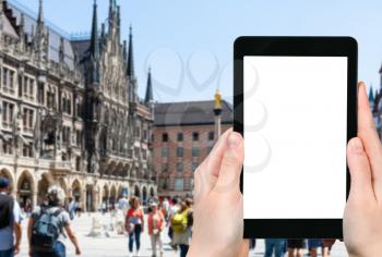 travel concept - tourist photographs of central Marienplatz (Mary's Square) in Munich city in Germany on smartphone with empty cutout screen with blank place for advertising