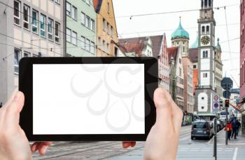 travel concept - tourist photographs of Karolinenstrasse and view of Perlachturm tower and Town Hall in Augsburg in Germany on smartphone with empty cutout screen with blank place for advertising