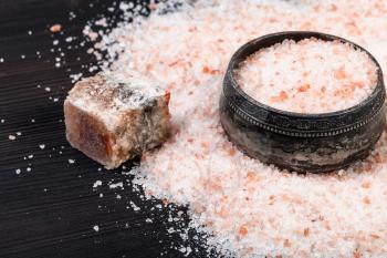 vintage silver salt cellar, raw natural pink Halite mineral and grained Himalayan Salt on dark brown wooden board